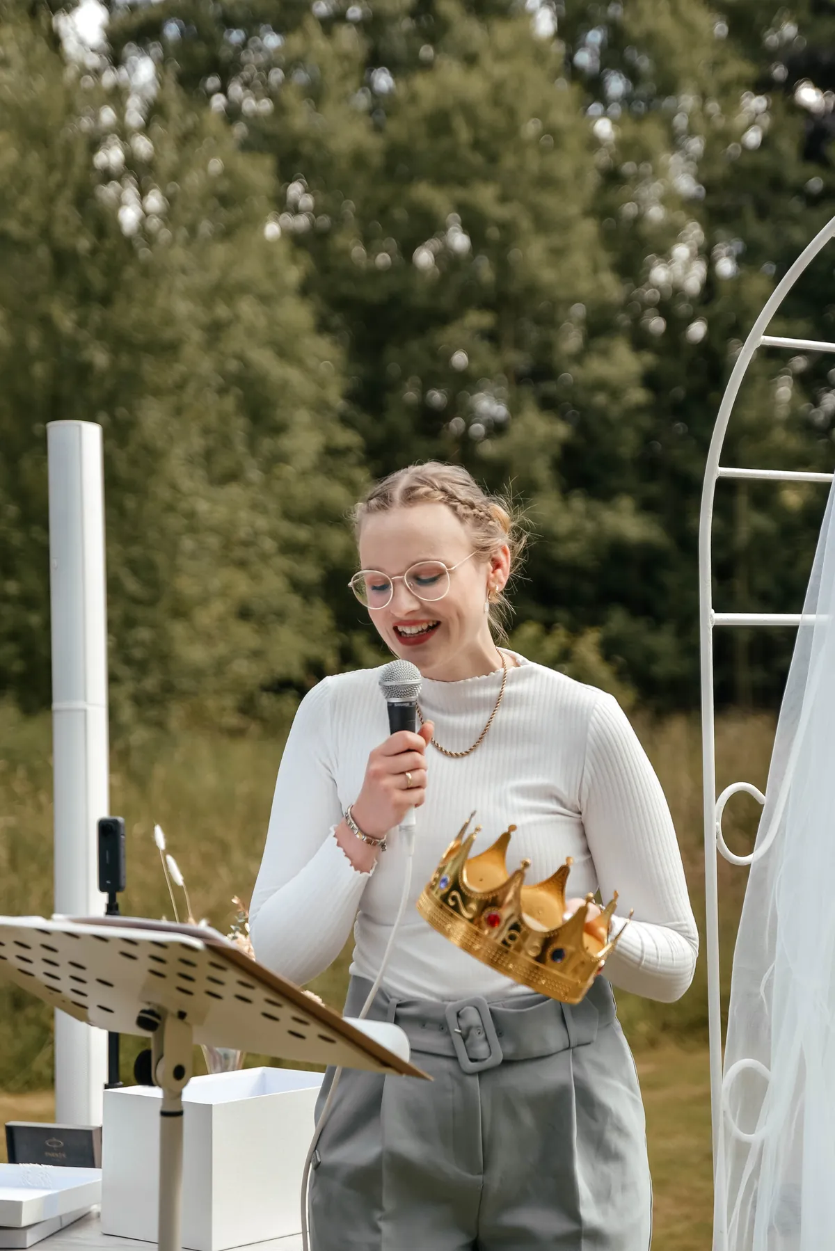 Emma lacht mit Mikrofon in der Hand während einer Rede